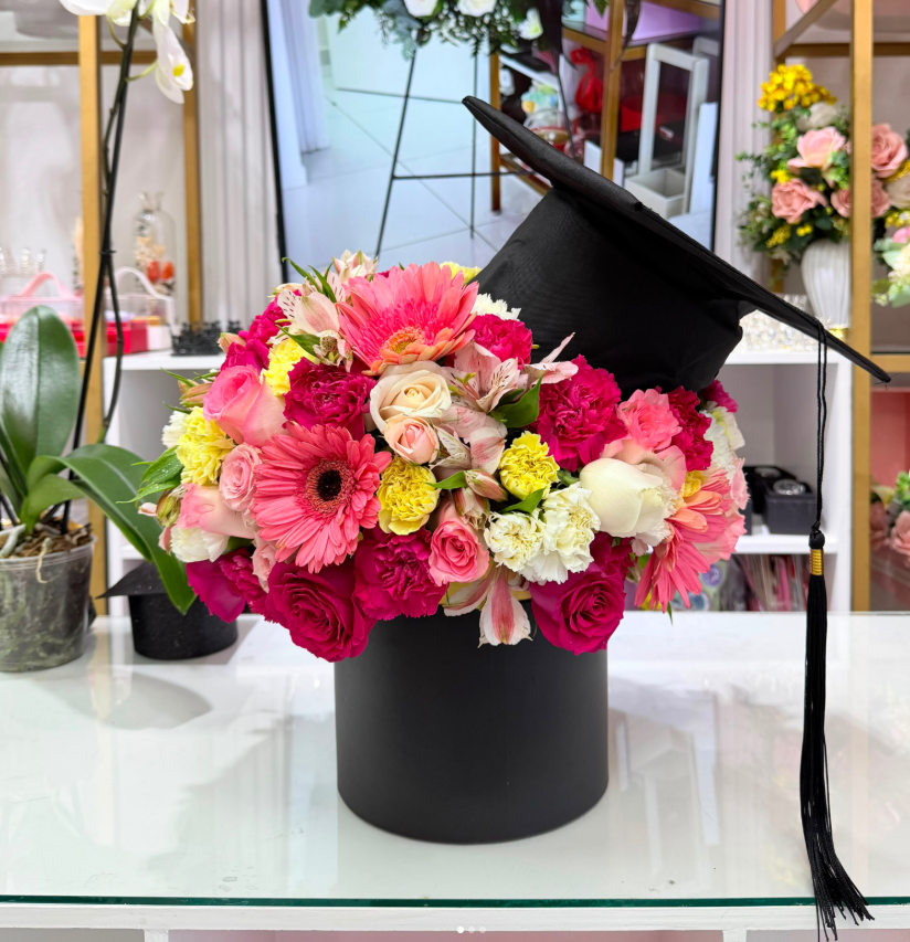 Arreglo de graduación con birrete y flores rosadas